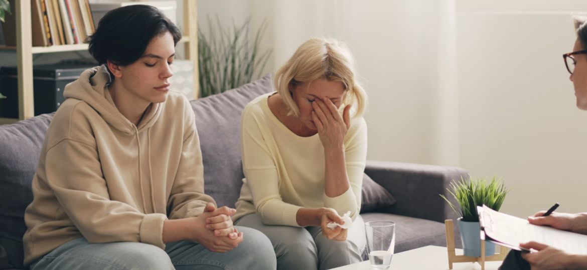 Adult child being comforted by a parent during addiction recovery support in Calgary