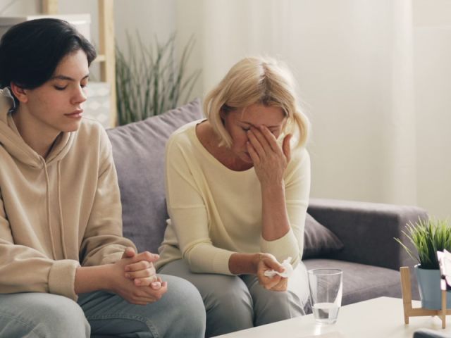 Adult child being comforted by a parent during addiction recovery support in Calgary