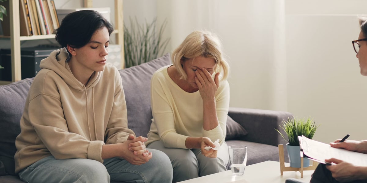 Adult child being comforted by a parent during addiction recovery support in Calgary