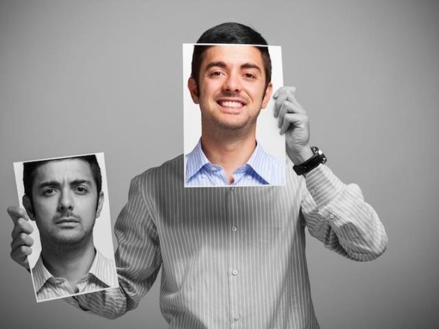 man holding up faces with different moods